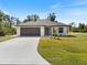 One-story home with dark brown garage door and light colored exterior at 509 Sunset N Rd, Rotonda West, FL 33947