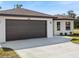 Dark brown garage door with light colored concrete driveway at 509 Sunset N Rd, Rotonda West, FL 33947