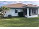 Home exterior showcasing a screened patio and grassy backyard at 6379 Grand Cypress Blvd, North Port, FL 34287