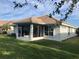 Home exterior showcasing a screened patio and grassy backyard at 6379 Grand Cypress Blvd, North Port, FL 34287