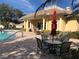 Community pool with lounge chairs, tables, and umbrellas at 6379 Grand Cypress Blvd, North Port, FL 34287