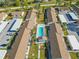 Community pool and surrounding buildings in aerial view at 6796 Gasparilla Pines Blvd # 77, Englewood, FL 34224