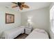 Spacious bedroom with twin beds, ceiling fan, and a calming atmosphere at 6796 Gasparilla Pines Blvd # 77, Englewood, FL 34224