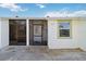 Exterior view of condo with front door, screened porch, and neutral color scheme at 6796 Gasparilla Pines Blvd # 77, Englewood, FL 34224