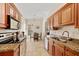 Kitchen view with stainless steel appliances, wood cabinets, granite counters, and a breakfast nook at 1117 Topelis Dr, Englewood, FL 34223