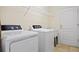 Functional laundry room features a washer, dryer, and sink, with shelving for storage and a utility door at 1117 Topelis Dr, Englewood, FL 34223