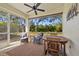 Well-appointed screened porch with a ceiling fan, offering a serene view of the surrounding landscape at 1117 Topelis Dr, Englewood, FL 34223