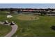 Aerial view of golf course with sand traps, water features, and homes at 1207 Highland Greens Dr, Venice, FL 34285