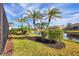 Landscaped backyard with palm trees and canal view at 1207 Highland Greens Dr, Venice, FL 34285