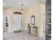 Elegant entryway with tiled floors, a glass-topped console table, and a mirror at 1207 Highland Greens Dr, Venice, FL 34285