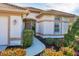 Front entrance with a curved walkway, landscaping, and a two-car garage at 1207 Highland Greens Dr, Venice, FL 34285