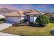 One-story house with a tile roof, white exterior, and landscaping at 1207 Highland Greens Dr, Venice, FL 34285