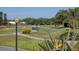 Golf course view with mature landscaping and homes in the background at 1207 Highland Greens Dr, Venice, FL 34285