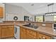 Kitchen area with wood cabinets, a stainless steel sink, and a view into the living area at 1230 Gantry Rd, North Port, FL 34288