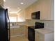 Kitchen with light cabinets, black appliances, and tile flooring at 1235 Saxony Cir # 5105, Punta Gorda, FL 33983