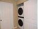 This laundry area features a stacked washer and dryer unit, with a white folding door at 1235 Saxony Cir # 5105, Punta Gorda, FL 33983