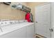 Well-equipped laundry room featuring washer, dryer, and ample shelving at 13298 Scrub Jay Ct, Port Charlotte, FL 33953