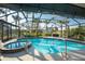 Inviting screened pool and spa with lush landscaping at 157 Angol St, Punta Gorda, FL 33983