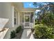 Screened porch entrance with walkway and lush green shrubs at 1577 Red Oak Ln, Port Charlotte, FL 33948