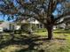 House exterior showcasing a large oak tree and spacious lawn at 1577 Red Oak Ln, Port Charlotte, FL 33948