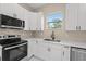 Modern kitchen with white cabinets and stainless steel appliances at 158 Chickering St, Port Charlotte, FL 33954