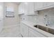 Bright laundry room featuring custom cabinetry, designer backsplash, and quartz countertops at 183 Maria Ct, Punta Gorda, FL 33950