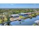 Aerial view showcasing the home, screened pool, canal access, and the surrounding lush landscape at 18390 Burkholder Cir, Port Charlotte, FL 33948