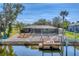 Backyard retreat with a screened-in pool, lush landscaping, and private dock access to the canal at 18390 Burkholder Cir, Port Charlotte, FL 33948