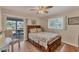 Bright bedroom features wood floors, ceiling fan and walkout access to the screened lanai at 18390 Burkholder Cir, Port Charlotte, FL 33948