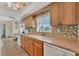 Well-lit kitchen featuring wood cabinets, modern appliances, and tile backsplash at 18390 Burkholder Cir, Port Charlotte, FL 33948