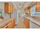 Kitchen features natural wood cabinets, stone backsplash, and white appliances at 18390 Burkholder Cir, Port Charlotte, FL 33948