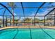 Screened in pool with a view of the canal, boat dock, and tropical landscaping at 18390 Burkholder Cir, Port Charlotte, FL 33948