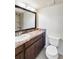 Bathroom featuring a granite countertop, dark wood cabinets, and a shower in the background at 1999 Kings Hwy # 16B, Punta Gorda, FL 33980