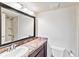 Bathroom featuring a granite countertop, dark wood cabinets, and a shower in the background at 1999 Kings Hwy # 16B, Punta Gorda, FL 33980