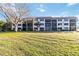 A full view of the building exterior with green lawn and palm trees on a sunny day at 1999 Kings Hwy # 16B, Punta Gorda, FL 33980