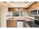 Galley-style kitchen featuring stainless steel appliances, solid surface countertops and a mosaic backsplash at 1999 Kings Hwy # 16B, Punta Gorda, FL 33980