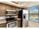 Kitchen with stainless steel refrigerator and oven range, enhanced by natural light from the adjacent window at 1999 Kings Hwy # 16B, Punta Gorda, FL 33980