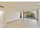 A brightly lit living room features new wood-style floors and sliding glass doors to a screened porch at 1999 Kings Hwy # 16B, Punta Gorda, FL 33980