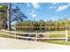 Scenic view of a serene pond surrounded by lush greenery and a charming wooden fence at 1999 Kings Hwy # 16B, Punta Gorda, FL 33980