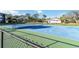 Community tennis court bordered by trees and a black chain link fence at 1999 Kings Hwy # 16B, Punta Gorda, FL 33980