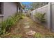 Stone pathway meanders through a lush, fenced backyard garden at 2202 Gold Oak Ln, Sarasota, FL 34232