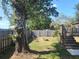 Serene backyard with a cozy fire pit, wooden fence, and lush trees, perfect for outdoor relaxation and entertaining at 2461 Ivanhoe St, Port Charlotte, FL 33952