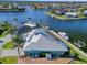 Aerial view of waterfront property on a canal with a dock, boat lift, and lush tropical landscaping at 2580 Brazilia Ct, Punta Gorda, FL 33950