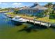 Rear of waterfront home shows a dock, boat, and screened lanai perfect for outdoor living at 2580 Brazilia Ct, Punta Gorda, FL 33950