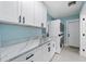 Bright laundry room with white cabinets, marble countertops, and stackable washer/dryer at 2726 N Beach Rd, Englewood, FL 34223