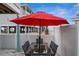 Outdoor patio with table and chairs, red umbrella, and beach view at 2726 N Beach Rd, Englewood, FL 34223