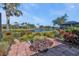 Landscaped backyard with lake view and brick patio at 3380 Bay Ridge Way, Port Charlotte, FL 33953