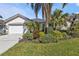 House exterior features white walls, a white garage door, and mature landscaping at 3380 Bay Ridge Way, Port Charlotte, FL 33953