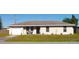 Tan one-story house with attached garage, small front yard, and landscaping at 3380 Maple Ter, Port Charlotte, FL 33952