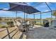 Screened patio with table, chairs, and umbrella overlooking a lake at 3533 Lakewood Blvd, North Port, FL 34287